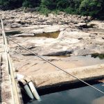 Foto do leito rochoso do rio com pouca água