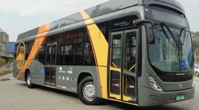 foto do ônibus elétrico. pintado de cinza e faixas amarelas; externamente é muito similar aos ônibus comuns