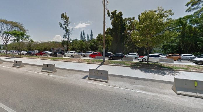 trecho não concluído da obra sobre a beira-mar, com carros passando ao fundo