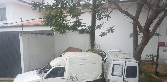 duas fiorinos arrombadas encostadas ao lado da rua e em cima de uma calçada