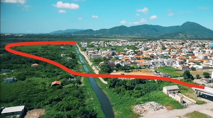 imagem aérea do bairro por onde vai passar a rodovia destacada com uma linha vermelha em curvas