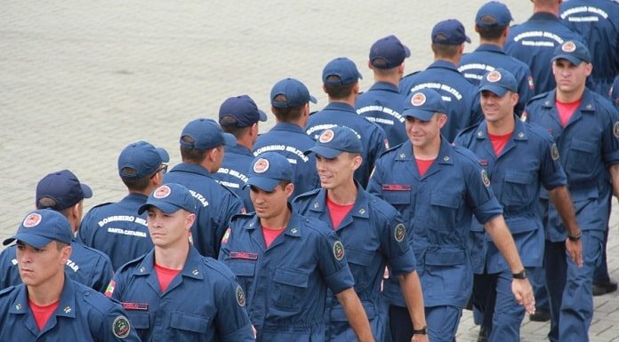 homens uniformizados marchando em duas linhas opostas, uma para cada lado, paralelamente