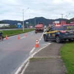 caminhonete da prf ao lado de balão inflável na lei seca sobre canteiro ao lado de marginal onde há cones