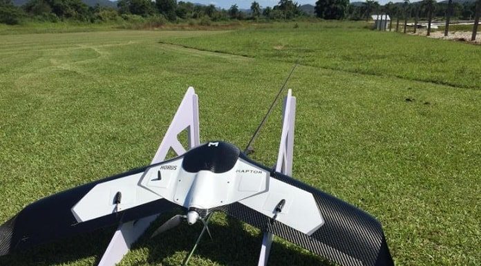 drone acoplado em um pequeno trilho de lançamento inclinado e apoiado no chão de grama