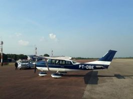 aeronave de prefixo pt-dbe estacionada em aeroporto com viatura ao lado