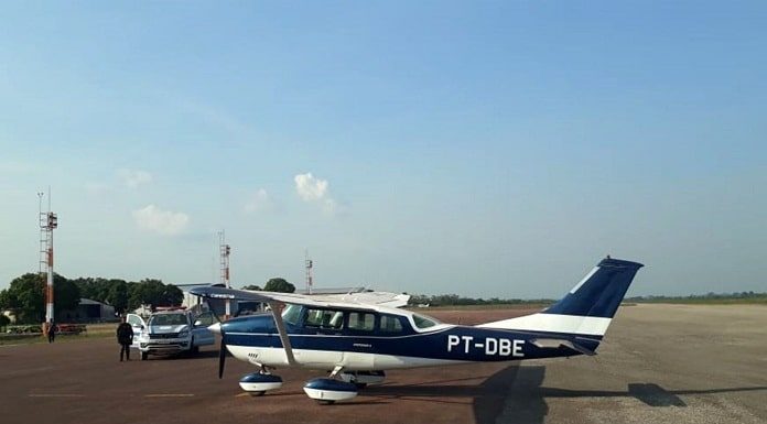 aeronave de prefixo pt-dbe estacionada em aeroporto com viatura ao lado