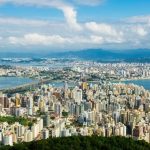 iptu 2021 Florianópolis: foto do alto do morro da cruz mostrando centro de florianópolis, continente e região metropolitana com céu com nuvens ao fundo