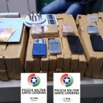 pacotes de maconha e aparelhos de celulares apreendidos pelos policiais, em cima de uma mesa