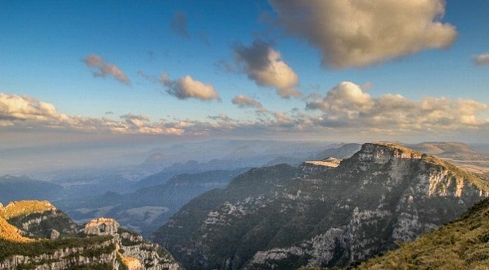 morro da pedra furada com montanhas em volta e vale ao fundo, nuvens no ceu