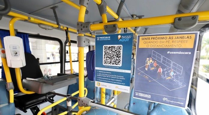 placa com qr code ao lado de catraca dentro de ônibus