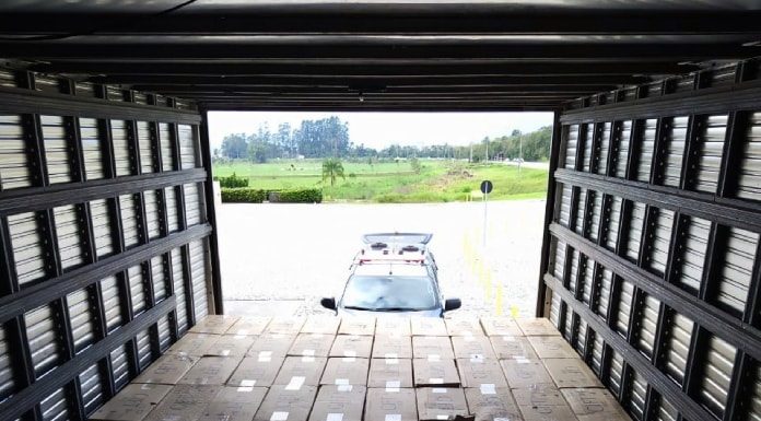 foto de dentro do baú do caminhão sobre todas as caixas de cigarros gift organizadas; ao fundo baú aberto e viatura lá fora