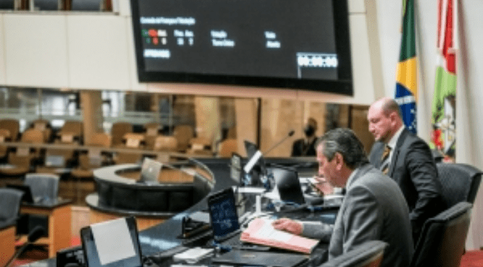 Dois homens sentados na tribuna da Assembléia Legislativa