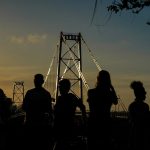 silhueta de seis pessoas à frente da ponte hercílio luz