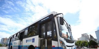 ônibus azul e branco na rua, com um céu azul ensolarado ao fundo. A partir de sábado, quem for se vacinar na capital terá passagem gratuita e dispensa do trabalho no dia da vacinação.